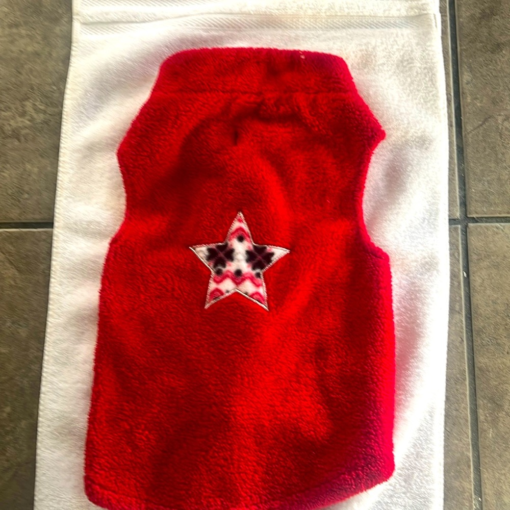 Small red dog coat with a star on the back , in good condition .